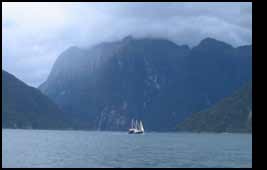 boat dwarfed by cliffs